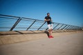 Young athlete holding bottle of water on the beach after morning jog or bodyweight training on the outdoor sportsground