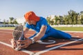 Young athlete male stretching his leg on a track in stadium, preparing for running and jogging workout. Caucasian man exercising Royalty Free Stock Photo