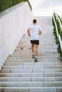 Young athlete man do morning run. Male runs up the stairs doing cardio exercises