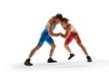 Young athlete man, wrestlers in blue and red uniform hand wrestling in motion against white studio background.