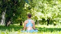 Young athlete meditates sitting in yoga asana lotus after exercises on green park
