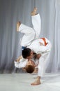 Young athlete with an orange belt performs technique nage-waza