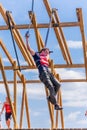 Young athlete participant in a race of heroes jumps from a bungee