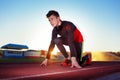 Young athlete runner in a position of readiness to start