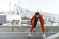 Young athlete stop to rest while running. Copy space. Tired woman bending over to catch her breath jogging in modern city Royalty Free Stock Photo