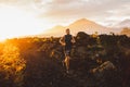 Young athlete trailrunning in mountains at sunrise