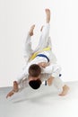 Young athletes in kimono are performing throws