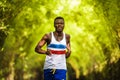 Young athletic and attractive black African American runner man doing running workout training outdoors on urban city park in Royalty Free Stock Photo