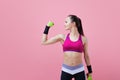 A young athletic attractive brunette girl with a ponytail shows off her biceps, holding dumbell in hand. Girl power.