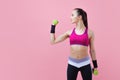 A young athletic attractive brunette girl with a ponytail shows off her biceps, holding dumbell in hand. Girl power.