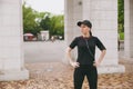 Young athletic beautiful brunette girl in black uniform, cap with headphones doing sport exercises, warm-up before Royalty Free Stock Photo