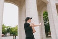 Young athletic beautiful brunette girl in black uniform, cap with headphones doing sport exercises, warm-up before Royalty Free Stock Photo