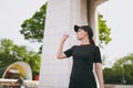 Young athletic beautiful brunette girl in black uniform and cap holding bottle, drinking water during training before Royalty Free Stock Photo