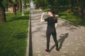 Young athletic beautiful brunette girl in black uniform and cap holding bottle, drinking water during training before Royalty Free Stock Photo