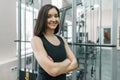 Young athletic confident woman fitness instructor posing in gym with folded crossed arms, looking in camera Royalty Free Stock Photo