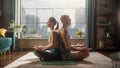 Young Athletic Couple Exercising, Practising Meditation in the Morning in Her Bright Sunny Home Royalty Free Stock Photo