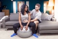 Young couple are training doing gymnastics at home