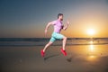 Young athletic and fit american sport man doing running workout on sunset at the beach training jogging barefoot in Royalty Free Stock Photo