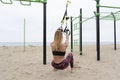 Young athletic fitness woman exercising doing suspension training with trx fitness straps on bars outdoor beach gym.Crossfit Royalty Free Stock Photo