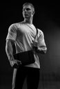 Athletic man in white t-shirt with black bag over his shoulder Royalty Free Stock Photo