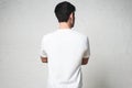 Young athletic guy in blank white t-shirt, back side, horizontal