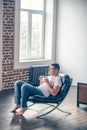 Young athletic guy in a chair drinking coffee. Royalty Free Stock Photo