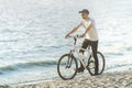 athletic man on a bike ride near the river . Royalty Free Stock Photo