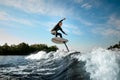 athletic man balancing on foilboard on wave on sunny day