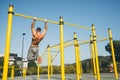 Young athletic man doing gymnastics on bars at a calisthenics park