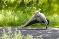 Young athletic man doing stretching exercises, outdoor. Healthy man working out in park Royalty Free Stock Photo