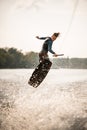 young athletic man jumps spectacularly on wakeboard above the water with splashes Royalty Free Stock Photo