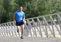 Young athletic man practicing running and sprinting on urban city park background in sport training Royalty Free Stock Photo