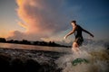 Young and athletic man riding on wakesurf down the river during Royalty Free Stock Photo