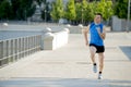 Young athletic man running on urban city park in summer sport training session Royalty Free Stock Photo