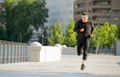 Young athletic man running on urban city park in summer sport training session Royalty Free Stock Photo