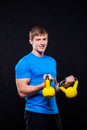 Young athletic man standing with kettlebells on