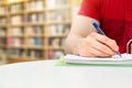 Young athletic man and student studying and writing notes.