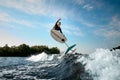 young athletic man vigorously jumping on the wave with foilboard