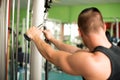 Young athletic man works out in fitness gym workout