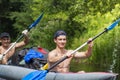 Young athletic men in boat rowing oars along the river on summer day. Canoe. Friends are swimming in a kayak Royalty Free Stock Photo