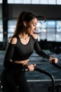 Young Athletic middle aged woman training on air resistance bike, cross training workout set in gym. Active woman spinning a air Royalty Free Stock Photo