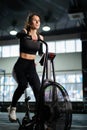 Young Athletic middle aged woman training on air resistance bike, cross training workout set in gym. Active woman spinning a air Royalty Free Stock Photo