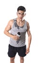 Young athletic sport man thirsty holding bottle of water with sweaty face and wet singlet Royalty Free Stock Photo