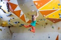 Young woman jumping on handhold in bouldering gym Royalty Free Stock Photo