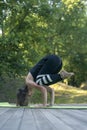 Young athletic woman practices yoga in park in crane pose. Bakasana. Yoga instructor during training