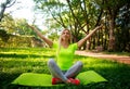 Young athletic woman practicing yoga exercises in city park Royalty Free Stock Photo
