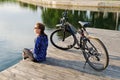 Young athletic woman in sportswear sits next to a bicycle Royalty Free Stock Photo