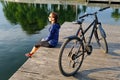 Young athletic woman in sportswear sits next to a bicycle Royalty Free Stock Photo