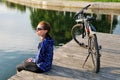 Young athletic woman in sportswear sits next to a bicycle Royalty Free Stock Photo