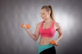 Young athletic woman works out with dumbbells